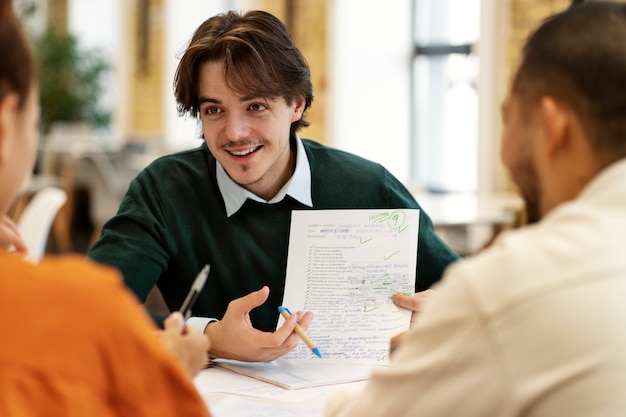 Free photo front view smiley man holding paper