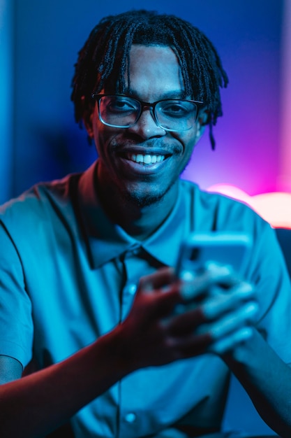 Free photo front view of smiley man holding smartphone in hands