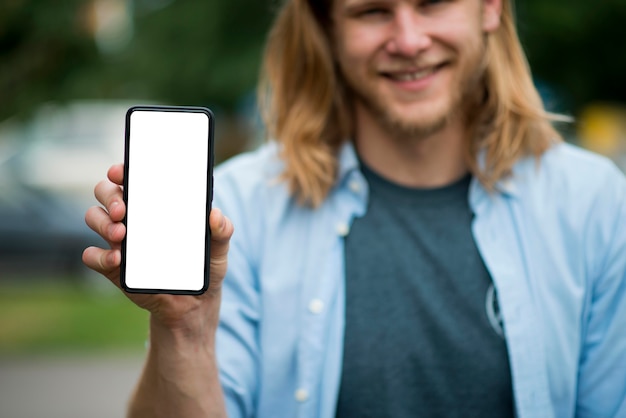 Front view of smiley man holding smartphone