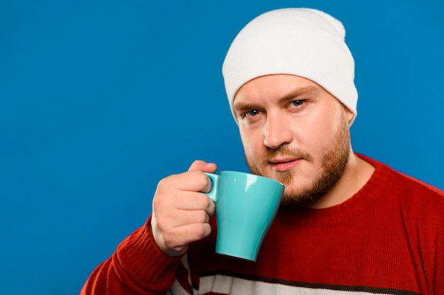 Front view smiley man holding up a cup of coffee