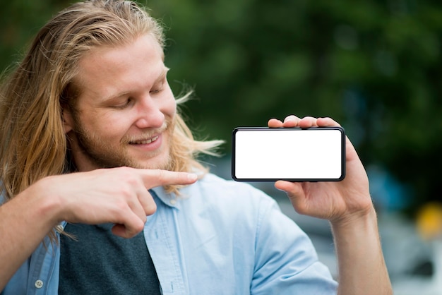 Vista frontale dell'uomo di smiley che indica al telefono