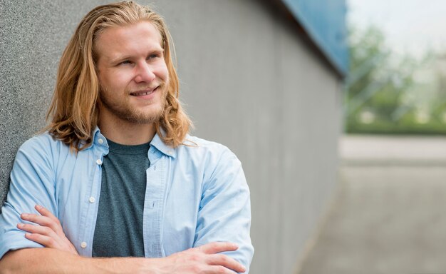 Free photo front view of smiley man posing outdoors