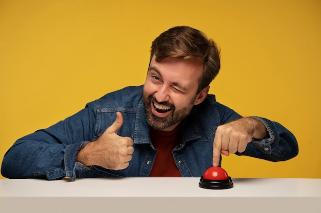 Uomo sorridente di vista frontale che preme un cicalino