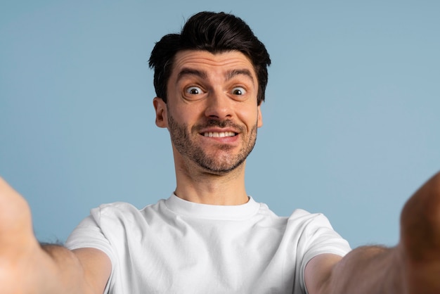 Vista frontale dell'uomo di smiley che prende un selfie