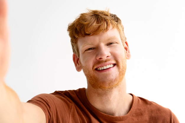 Front view smiley man taking selfie