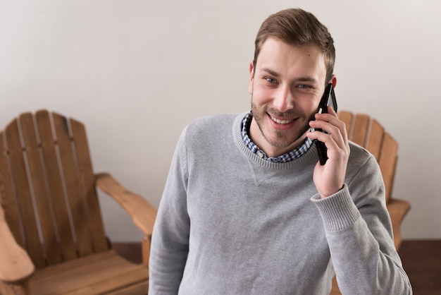 Front view of smiley man talking on the phones