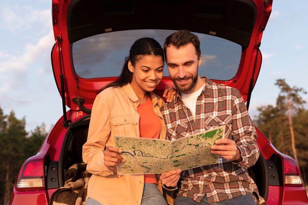 Free photo front view smiley man and woman checking a map