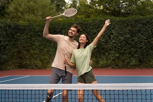 Gente sorridente di vista frontale sul campo di badminton