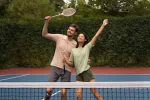 Free photo front view smiley people on badminton field