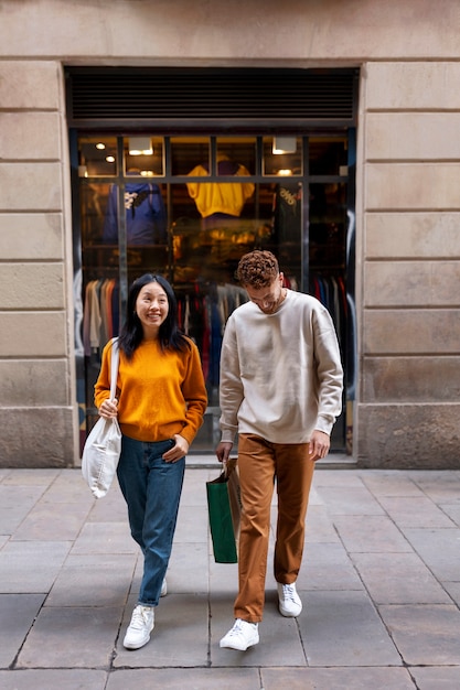 Free photo front view smiley people carrying bags