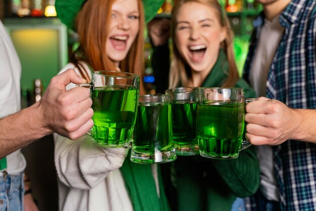 front view of smiley people celebrating st. patrick's day at the bar