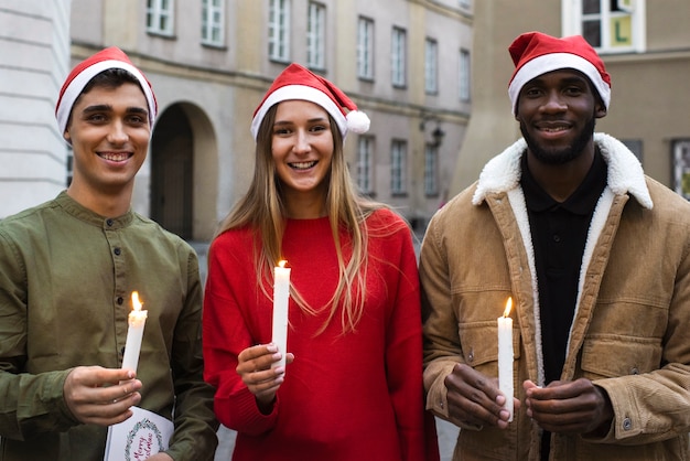 Free photo front view smiley people holding candles