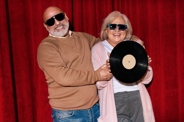 Free photo front view smiley people holding vinyl record