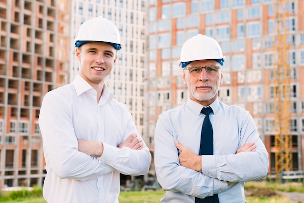 Front view smiley people with helmets and crossed arms