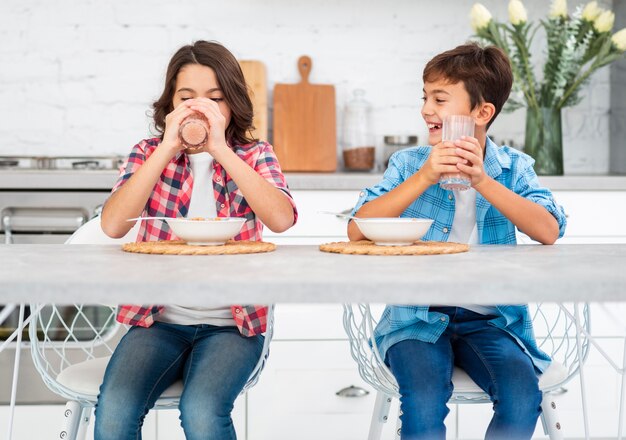 Front view smiley siblings eating together