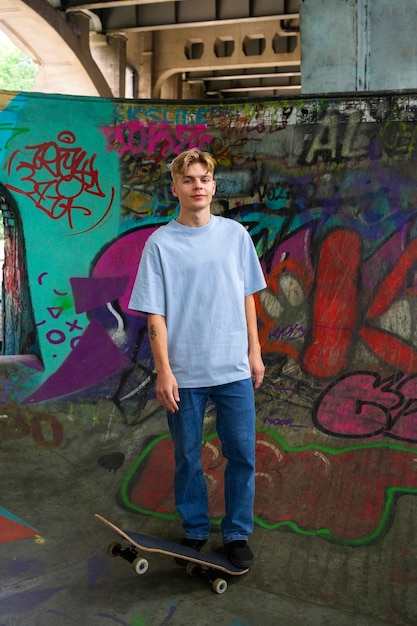 Front view smiley teen with skateboard