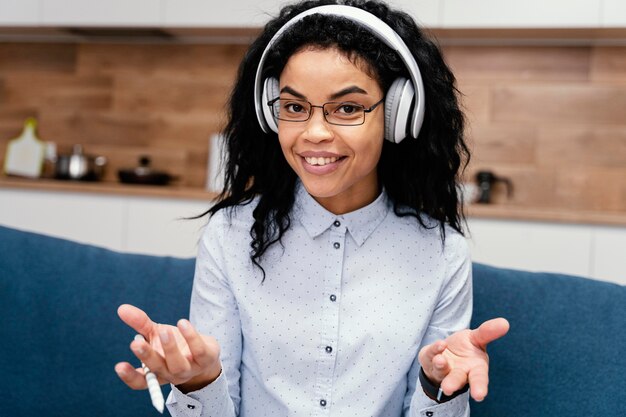 Front view of smiley teenage girl with headphones during online school