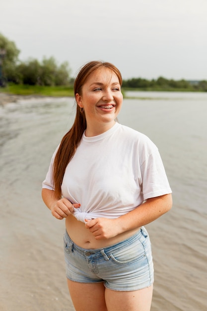 Front view of smiley woman at the beach