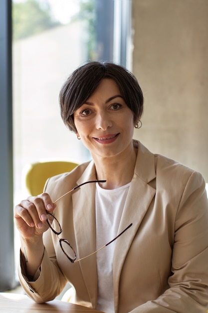 Free photo front view smiley woman in cozy office