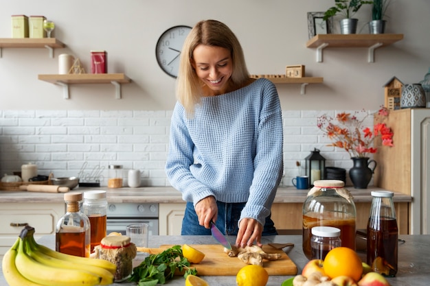 Front view smiley woman cutting ingredients