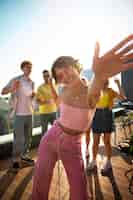 Foto gratuita donna sorridente di vista frontale che balla all'aperto