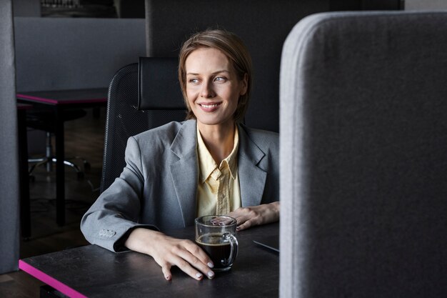 Front view smiley woman at desk