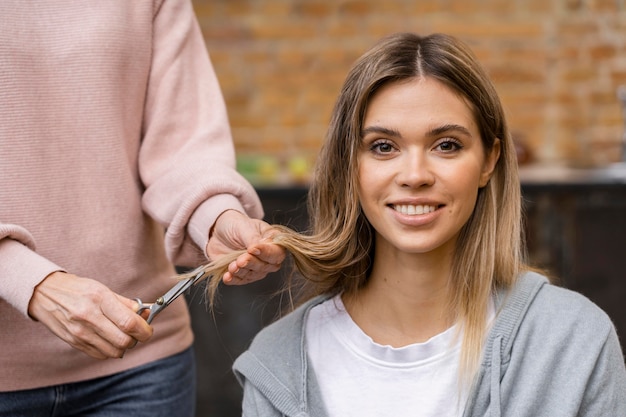 Front view of smiley woman getting a haircut