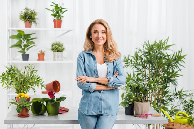 Free photo front view smiley woman in greenhouse