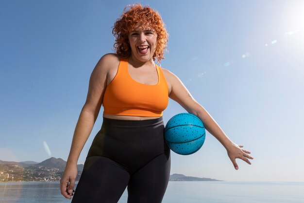 Front view smiley woman holding ball