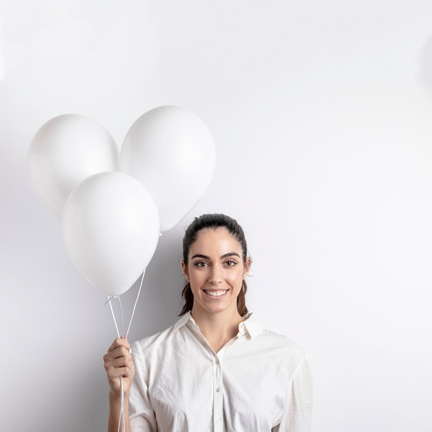 Free photo front view of smiley woman holding balloons