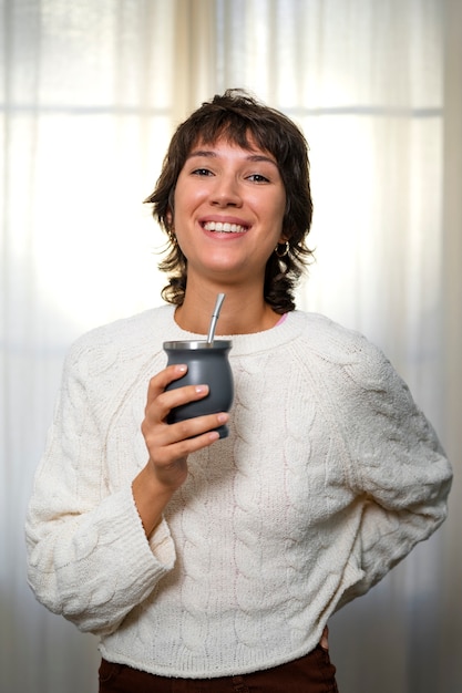 Foto gratuita donna di smiley di vista frontale che tiene tazza