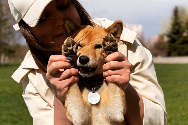 かわいい犬を保持している正面スマイリー女性