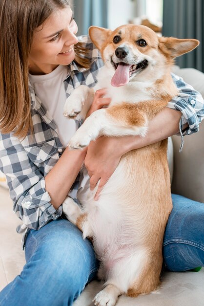 犬を保持しているスマイリー女性の正面図