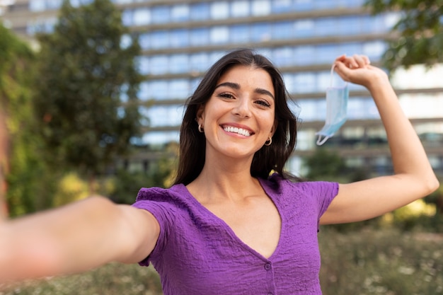 Free photo front view smiley woman holding face mask