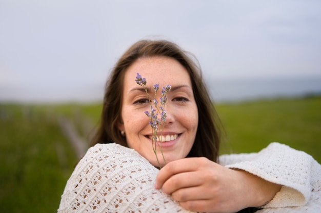 Foto gratuita fiore della holding della donna di smiley di vista frontale