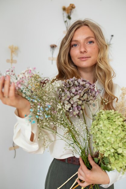 Front view smiley woman holding flowers