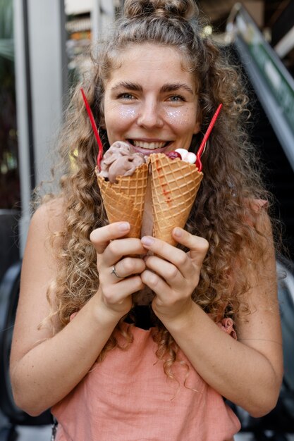 Front view smiley woman holding ice cream cones