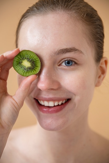 Front view smiley woman holding kiwi