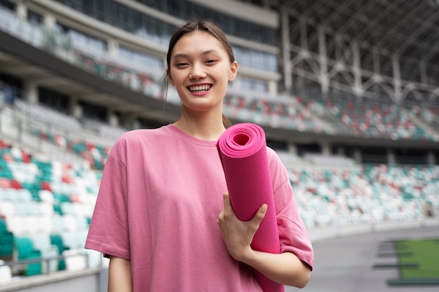 Free photo front view smiley woman holding mat