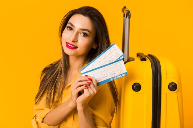 Вид спереди смайлик женщина, держащая билеты на самолет