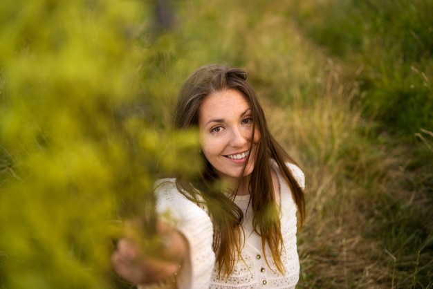 Front view smiley woman holding plants