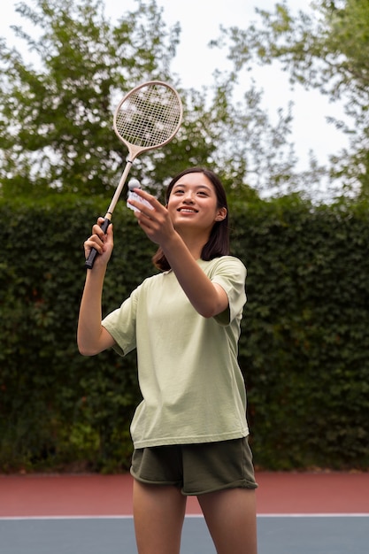 Front view smiley woman holding racket