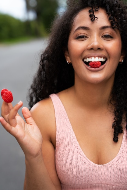 Front view smiley woman holding raspberries