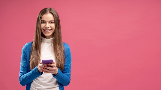 Front view of smiley woman holding smartphone