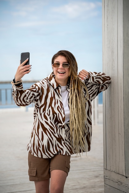 Free photo front view smiley woman holding smartphone