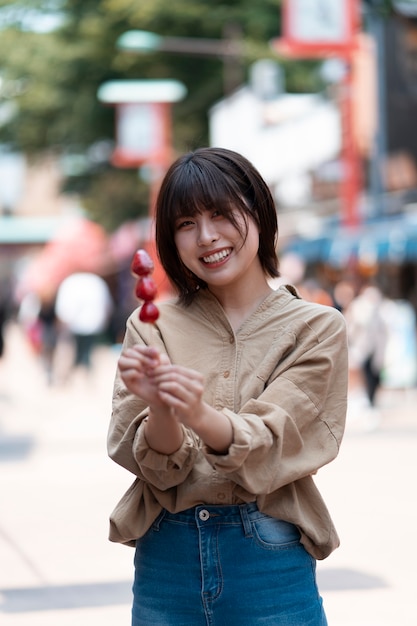 Foto gratuita donna sorridente di vista frontale che tiene cibo gustoso