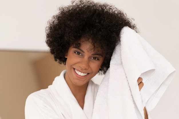 Вид спереди улыбающаяся женщина, держащая полотенце