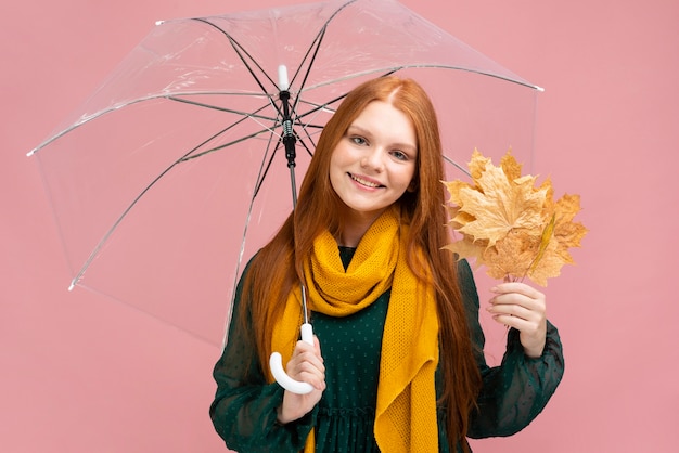 Foto gratuita ombrello della tenuta della donna di smiley di vista frontale