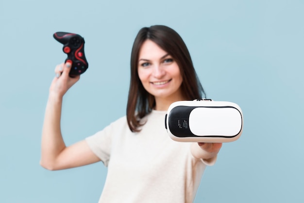 Free photo front view of smiley woman holding virtual reality headset