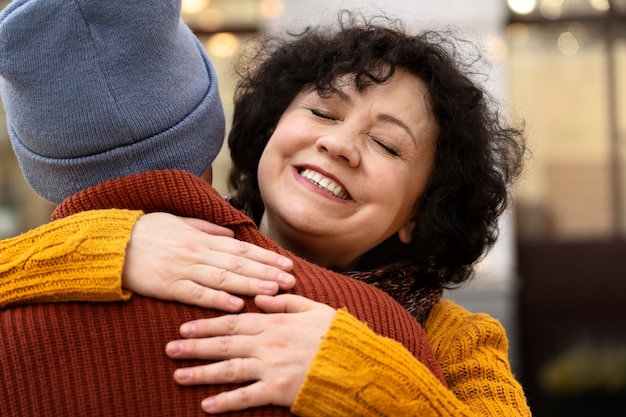 Front view smiley woman hugging friend